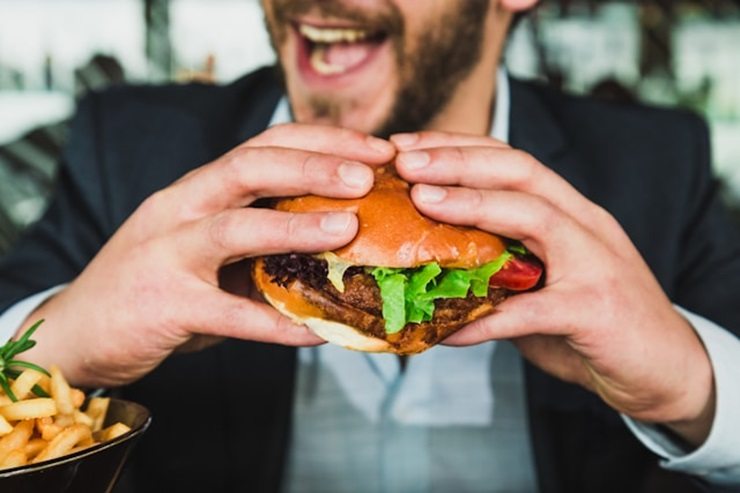 Uomo mangia hamburger