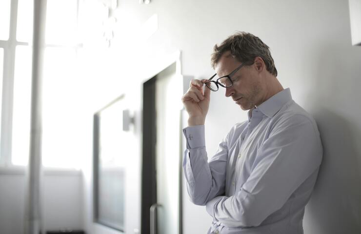 uomo stressato si toglie gli occhiali